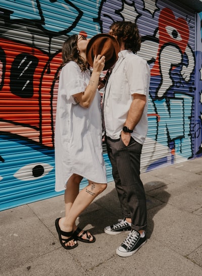 During the day, a man and a woman standing beside the red and blue walls
